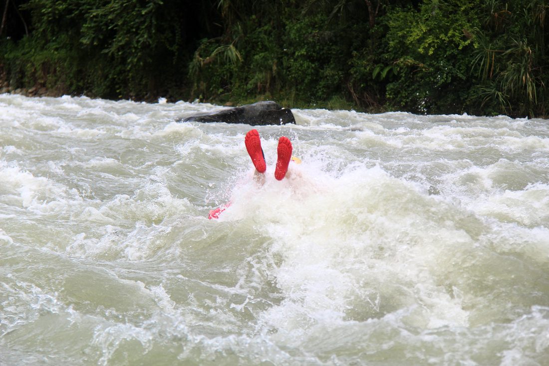 Only the feet of a tuber showing above a wave on the Savegre