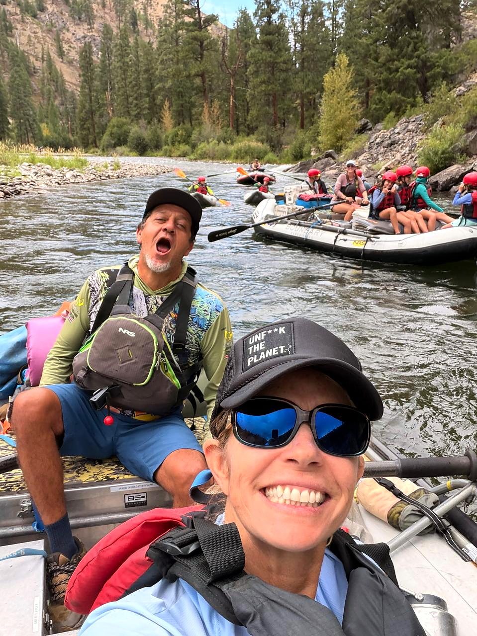 Leo and Cara on a raft trip, Cara taking a selfie in front and Leo singing behind her