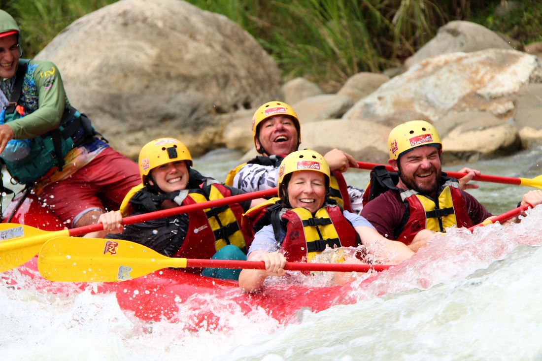 Family laughing in a raft on the Naranjo river