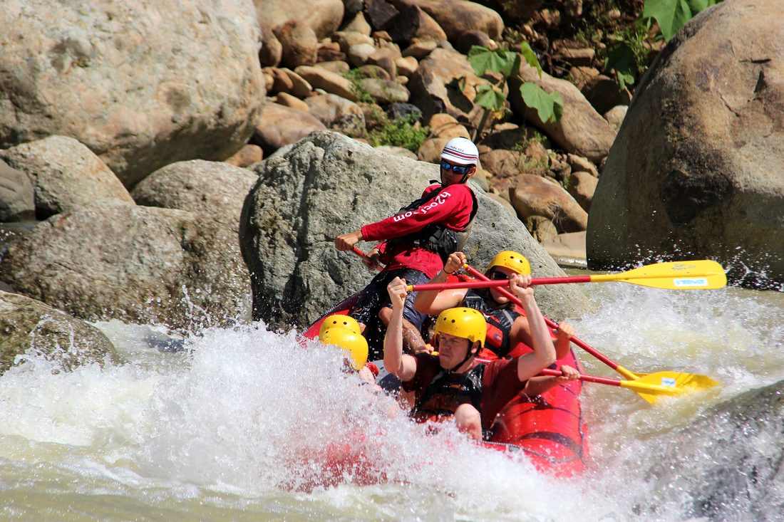 A family paddling through splashes between the rocks on the Naranjo
