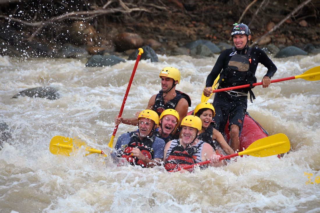 A family holding on as the raft hits a wave on the Naranjo