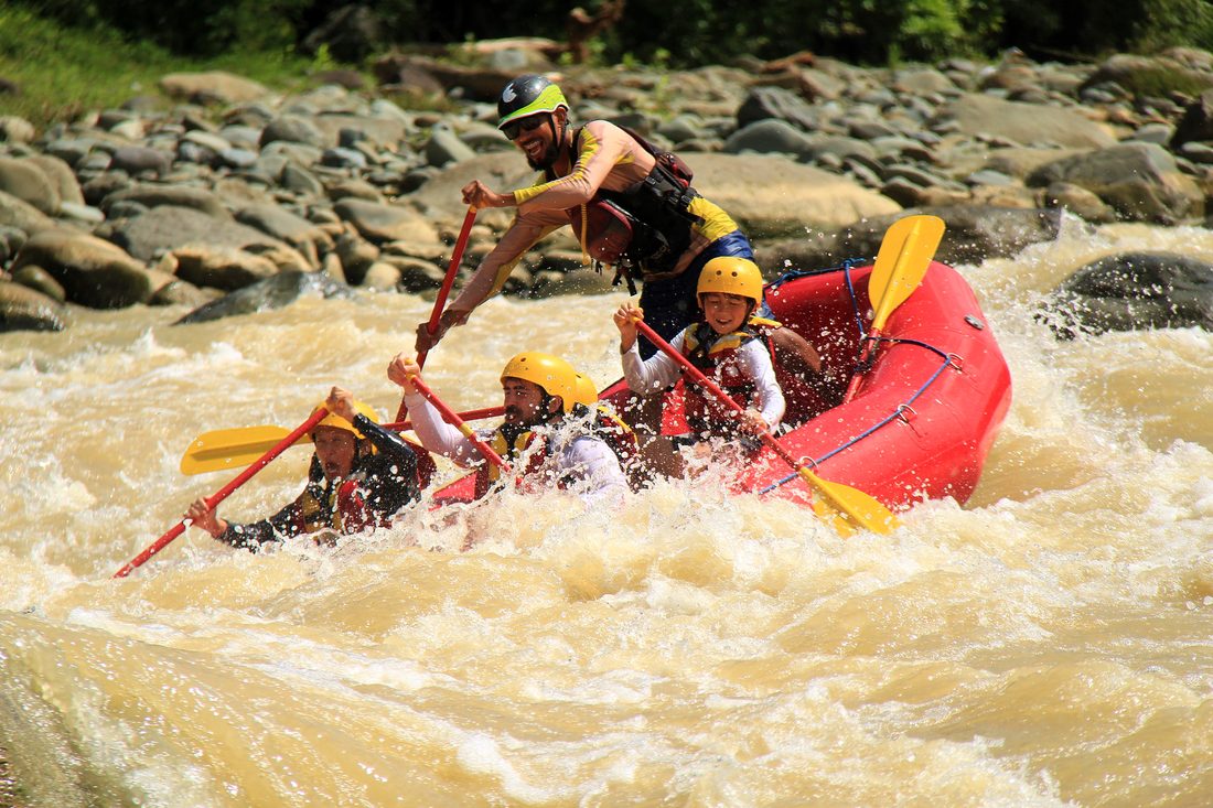 Guide leaning in as the raft drops into a rapid on the Naranjo